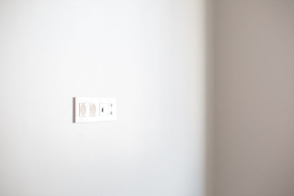 Close-up of a white wall featuring a modern electrical outlet, ideal for design concepts.
